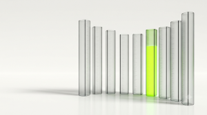 Eight tall translucent glass gauge columns of different heights arranged in a gentle curved row on a clean reflective white floor, seven of them clear and softly frosted with faint measurement lines, one glowing with lime green